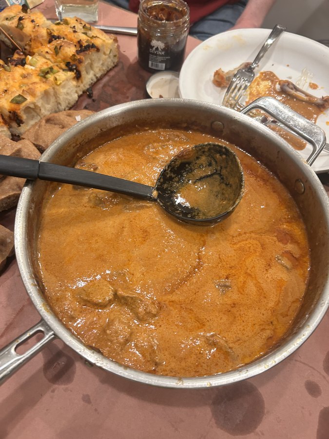 Chicken Ruby finishing in its tomato and cream sauce, a ladle resting in the pan